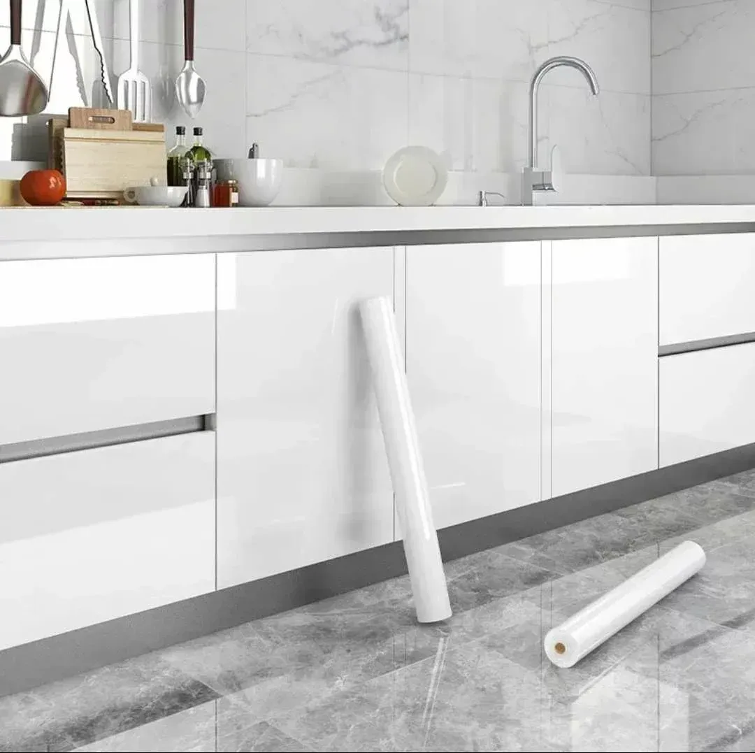 Möbelfolie wird auf weiße Küchenfronten aufgetragen